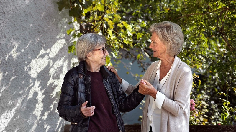 Ältere und jüngere Seniorin draussen unterwegs.