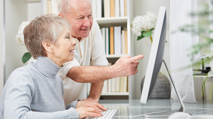 zwei Senioren schauen ins Internet